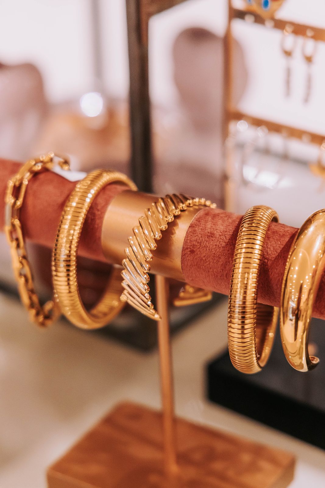 Sieraden: gouden armbanden op een houder in de winkel van KUIF