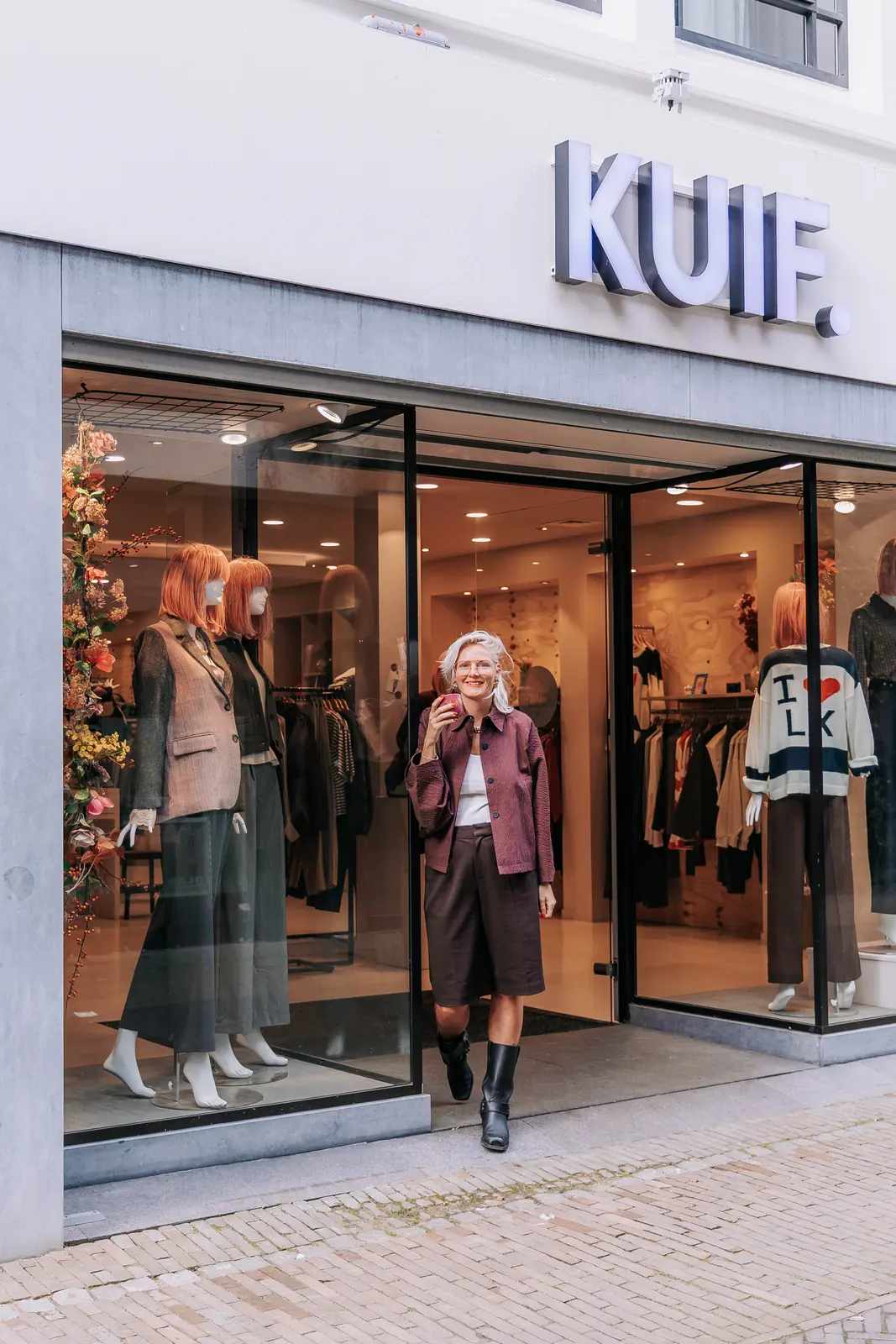 Ellie voor de gevel van KUIF aan de Klaasstraat in Venlo, met het woordmerk boven de deur